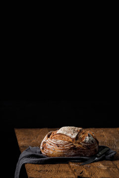 Rustic crispy sourdough bread with cranberries on a wooden table. Vertical panoramic view, free space for text