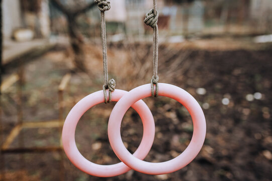 Homemade round plastic rings hanging on a rope outdoors for sports, gymnastics. Photography, children's entertainment concept.