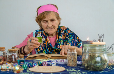 Woman fortune teller prepares a potion. Selective focus.