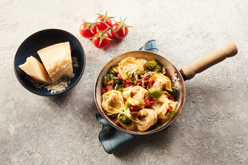 Delicious tortelloni pasta with tomatoes broccoli and cheese