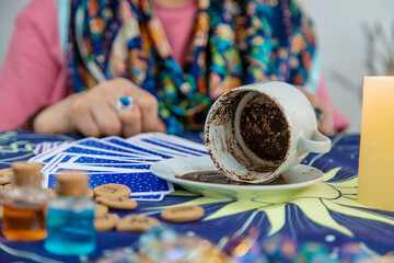 A fortune teller reads fortunes on coffee grounds. Selective focus.