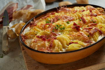 Delicious cheesy potato gratin in casserole pan on table