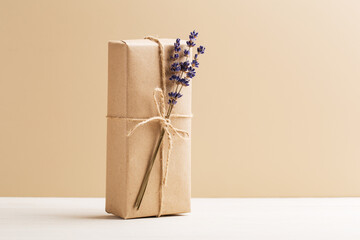 Craft gift box with lavender bouquet on a light wooden table. Eco-friendly concept. Rustic style....