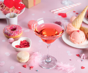 Romantic sweet dessert table with glass of pink wine, waffles, donut, ice cream, macaron, lollipop, candies. Valentine's day concept