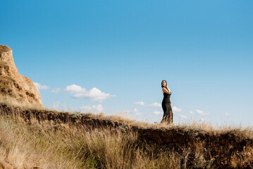 tall girl model in a black dress on the mountain hills