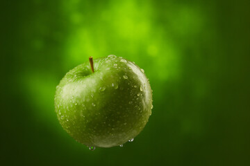 green apple with water drops on a green background. fresh fruit close-up. High quality 4k footage