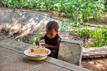  african mixed race toddler playing with a bowl