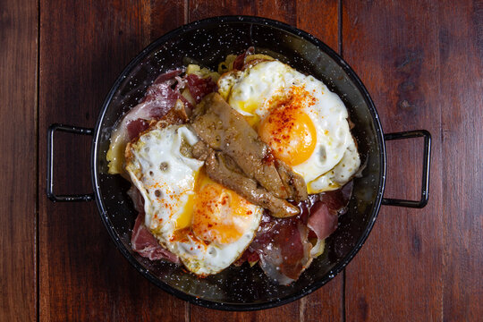 Huevos rotos with ham and fua