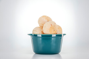 Isolated cheese breads in two green ramekins on white background.