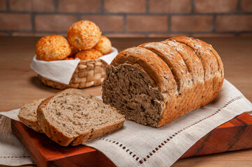 Wholemeal bread with cheese breads on a basket behinden.