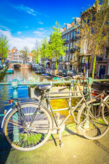 Fototapeta na wymiar Old bicycle next to canal of Amsterdam