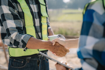 construction worker and contractor. Client shaking hands with team builder in renovation site in the morning.