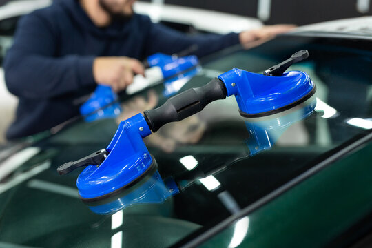 Glass of the car is a close-up in the room, removed with the help of professional suction cups. The process of car repair.