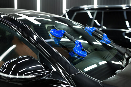 Glass of the car is a close-up in the room, removed with the help of professional suction cups. The process of car repair.