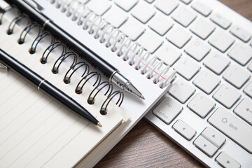 Pen and notepad on the computer keyboard.