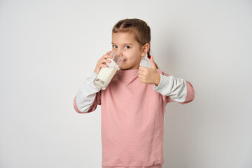 Cute girl drinking milk, white background, close-up