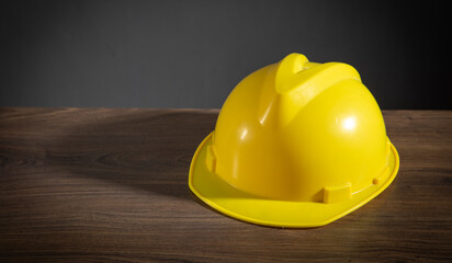 Fototapeta premium Yellow construction helmet on the wooden table.