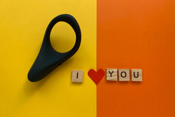 Sex product, assortment sex shop. Sex toy. Black cock ring on orange background. lettering I LOVE YOU. Flat lay © Olga Goretz
