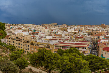 Fototapeta na wymiar Top view of a densely built city with dark clouds in the background