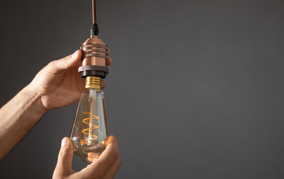 Man Changing Light Bulb At Home.