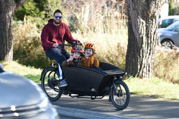 man carrying two children on a bicycle