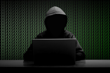 Mysterious man wearing black hoodie using laptop in the dark room. Hacker and cyber security, and...