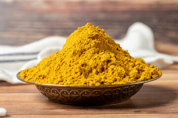 Curry Masala Powder. Turmeric powder or curry powder spice in a bowl on wooden background. İndian spices. Dry spice concept. close up