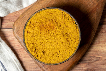 Curry Masala Powder. Turmeric powder or curry powder spice in a bowl on wooden background. İndian spices. Dry spice concept. Top view