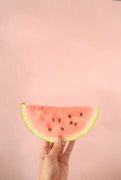 Person Holding  A Slice Of Watermelon In A Pink Background 