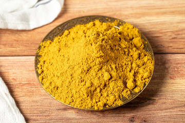 Curry Masala Powder. Turmeric powder or curry powder spice in a bowl on wooden background. İndian spices. Dry spice concept. close up