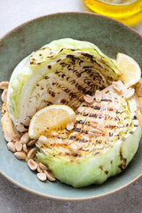 Close-up of grilled white cabbage wedges with peanuts and sauce, vertical shot, selective focus