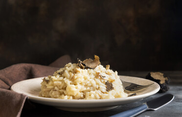 Risotto with porcini mushrooms and black truffles served in a plate top view, gourmet cousine