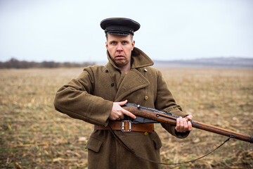 a soviet soldier holds a rifle in his hands and looks maliciously into the camera. rhetorical soldier