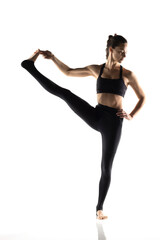 Portrait of young beautiful woman in black sportswear doing yoga practice.