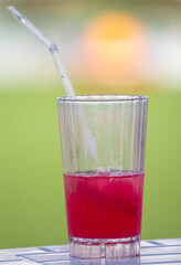 Red cocktail in a glass in nature.