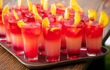 Red juicy cocktail with orange in cafe.