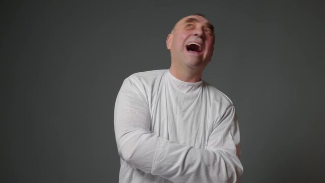 Elderly man have psychosis attack on gray background. Man with psychic disorders