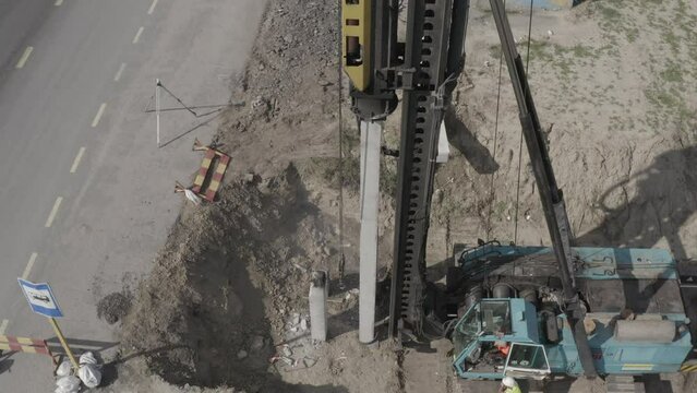 Pile driving machine driving piles into ground site. Modern hydraulic lifting mechanisms. Ukraine. 
