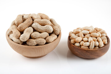 Bowl full of shelled and roasted peeled peanuts on white background, closeup