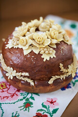 Ukrainian traditional holiday bread - loaf. Ukrainian decorated fresh loaf with salt lies on the table, next to the embroidered towel. Ukrainian wedding traditions.