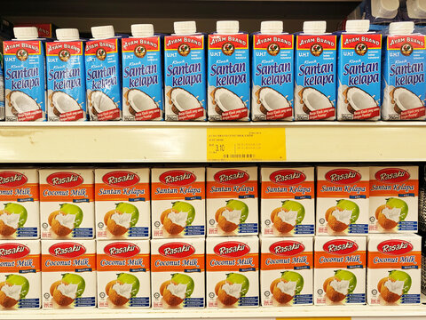 JOHOR, MALAYSIA -NOVEMBER 12, 2022: Selected focused on processed coconut milk packaged in commercial packaging and displayed in supermarkets. Sorted by brand and has a price tag.