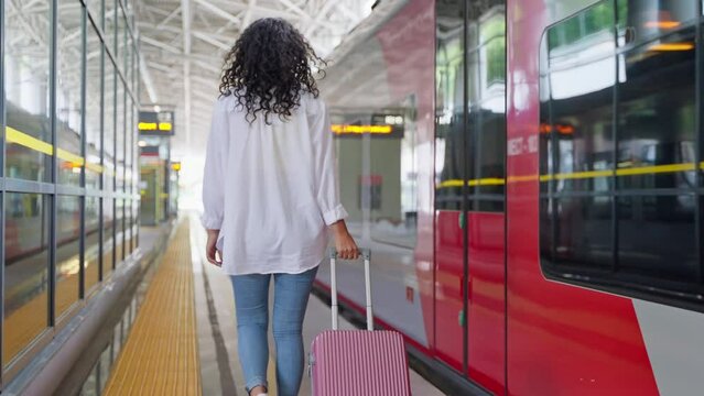 Female traveler with suitcase on the platform