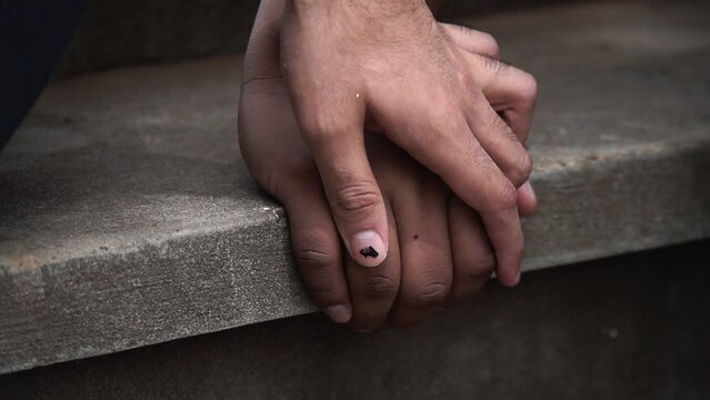 Diversidad. J&oacute;ven tocando por primera vez la mano de su amigo en una escalera. Gay se le declara a su compa&ntilde;ero. Mano peque&ntilde;a acariciando una mano grande.