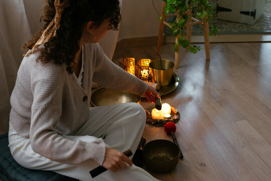 Young calm lady burning incense stick before aromatherapy