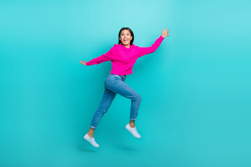 Fototapeta na wymiar Full length photo of shiny pretty girl dressed pink pullover hurrying jumping high isolated teal color background