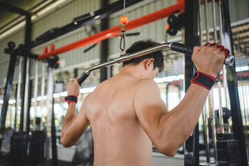 Asian man exercising with a barbell in the fitness