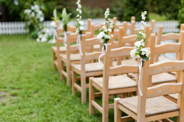 Wooden chairs with flowers wedding ceremony