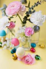 Fototapeta na wymiar Easter eggs, flowers on yellow background