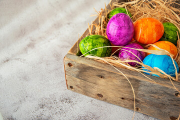 High angel view of multicolored  colorful Easter eggs in wooden box over gray background.Happy Easter greeting card.