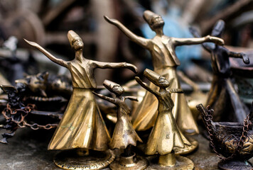 Pieces of dervishes in bronze and metal in antique shop. Sufi dancers